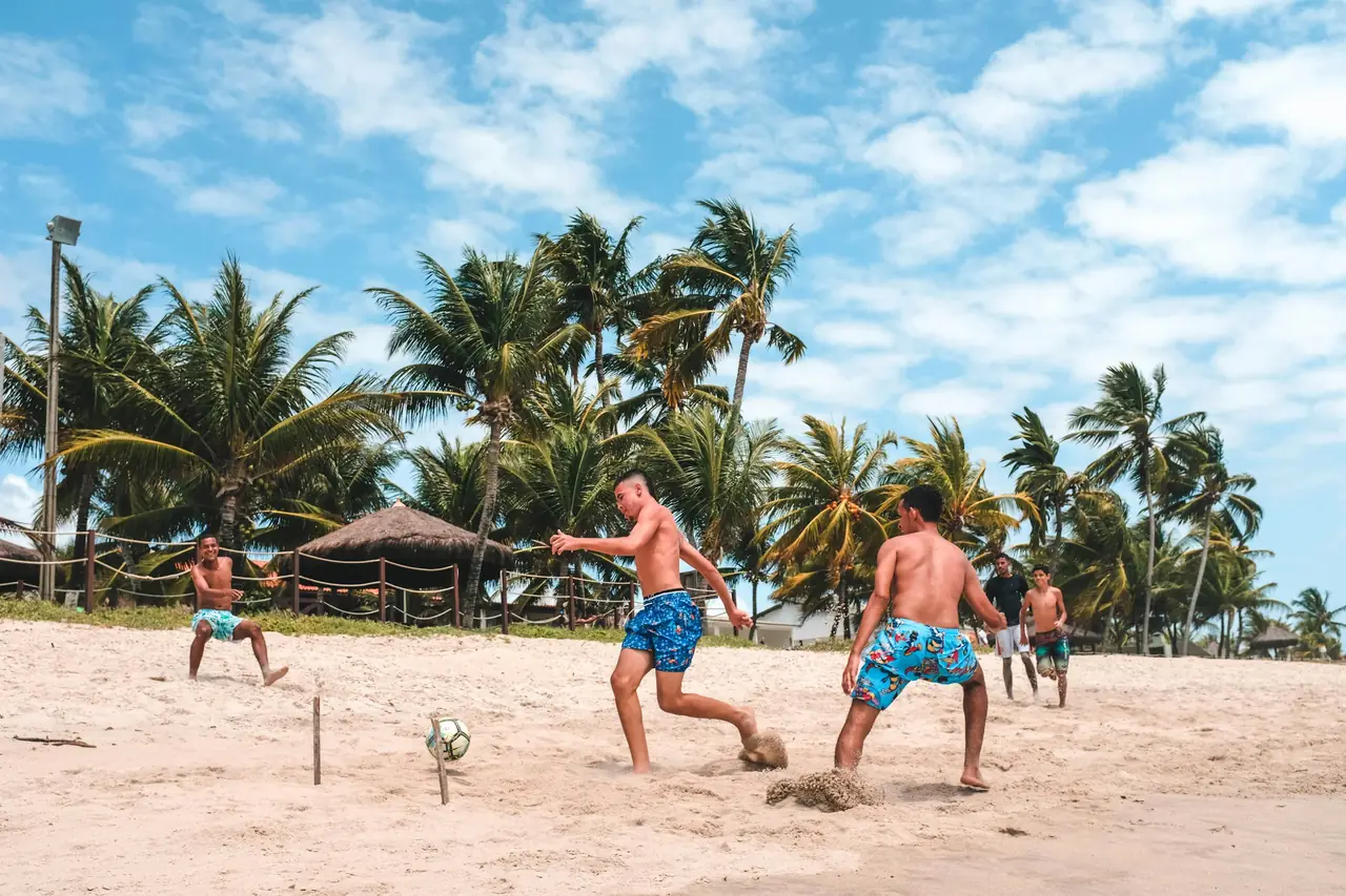 Beach soccer game among palm trees